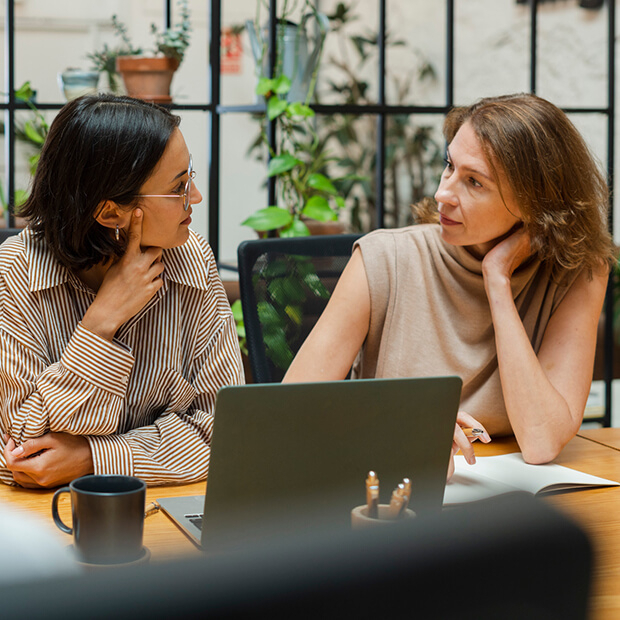 Two women in a coaching conversation, representing C-suite coaching and female leadership coaching
