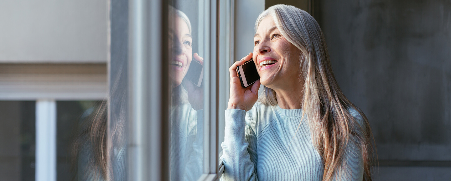 Smiling midlife woman on a phone call, symbolising confident career choices and exploring new career paths