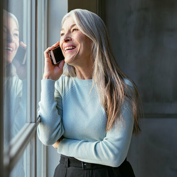 Smiling midlife woman on a phone call, symbolising confident career choices and exploring new career paths