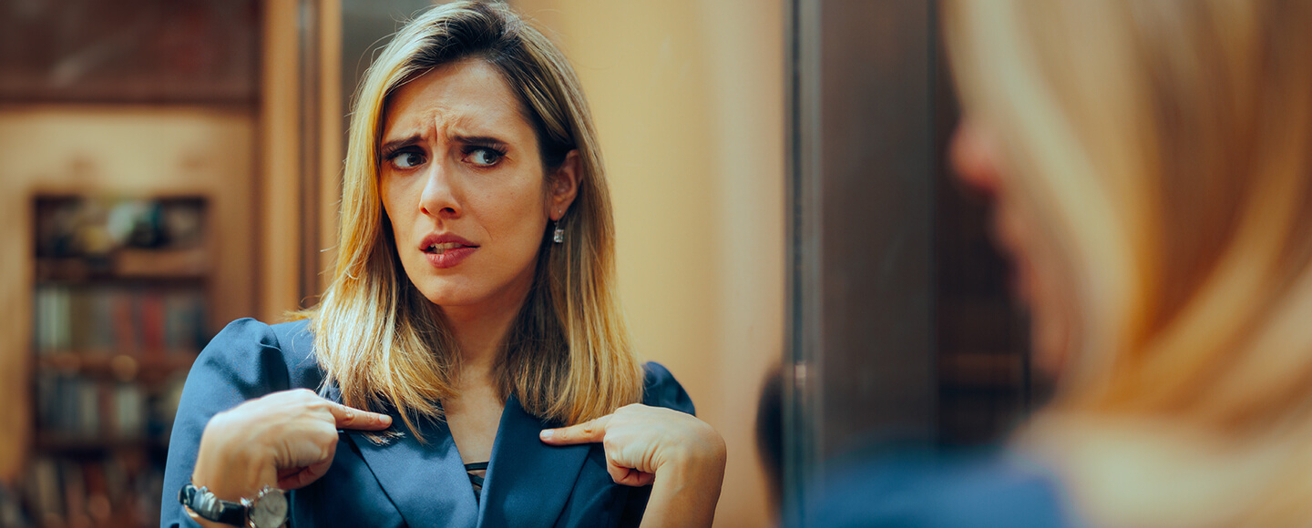 Woman questioning herself in the mirror, reflecting the emotional confusion often felt during a midlife crisis