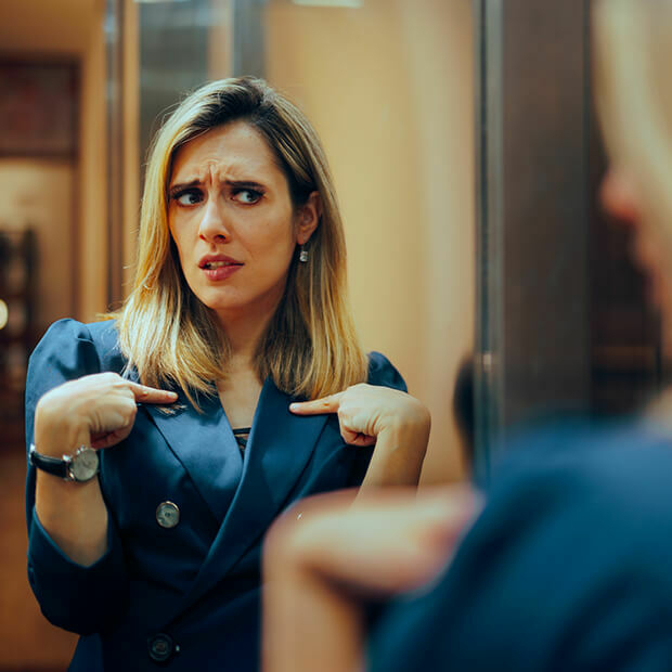 Woman questioning herself in the mirror, reflecting the emotional confusion often felt during a midlife crisis
