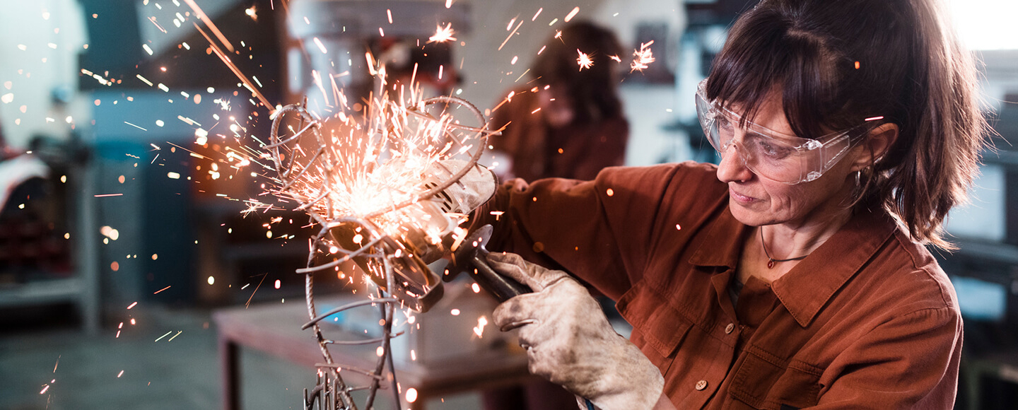 Woman welding a piece of art, symbolising creativity and midlife reinvention at 50+