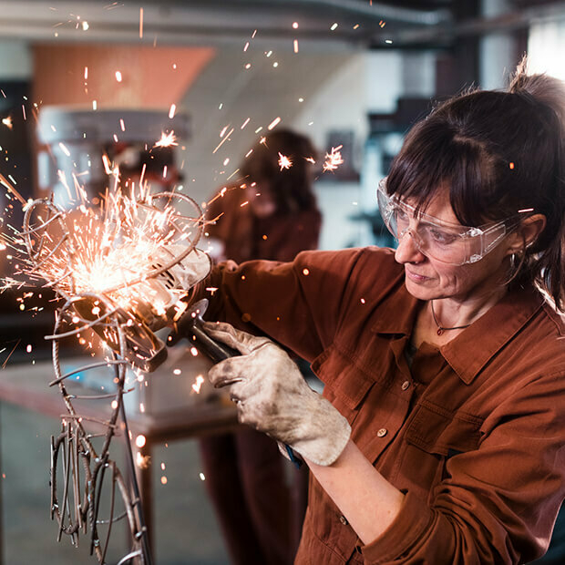 Woman welding a piece of art, symbolising creativity and midlife reinvention at 50+