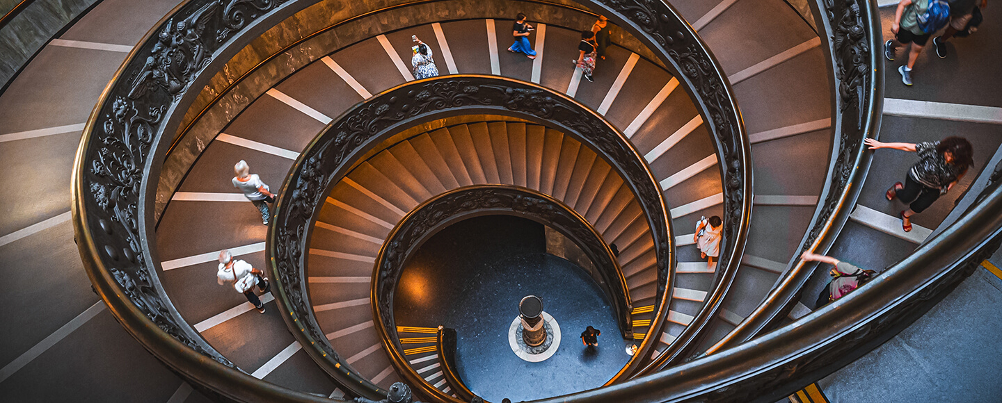 Spiral staircase seen from above, symbolising the looping patterns of limiting beliefs and the journey to break free