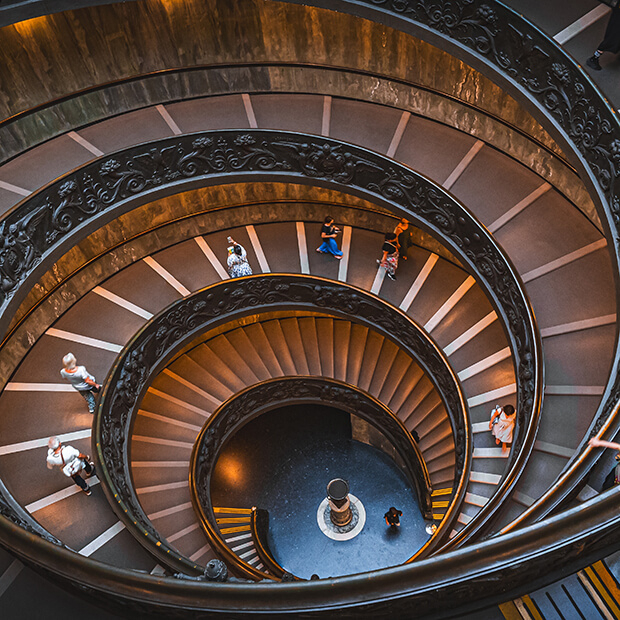 Spiral staircase seen from above, symbolising the looping patterns of limiting beliefs and the journey to break free
